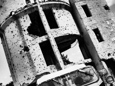 Gaz 69 na tle ostrzelanych budynków w Sarajewie