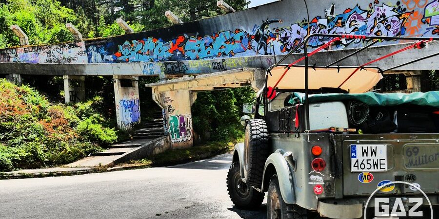 Zdjęcie przedstawia Gaza 69 na tle zniszczonego toru bobslejowego, który w 1984 roku wykorzystywany był podczas XIV Zimowych Igrzysk Olimpijskich w Sarajewie. Gaz 69 na tle toru bobslejowego w Sarajewie